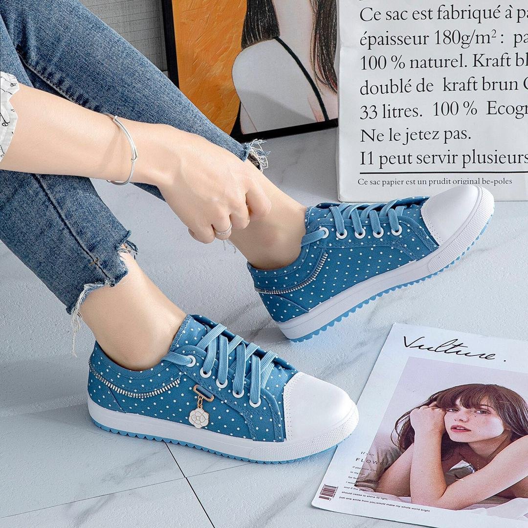 Sneakers and loafers in a vibrant blue color with white polka dots, featuring a zipper detail and a small flower charm. The image showcases the product's versatility and comfort.
