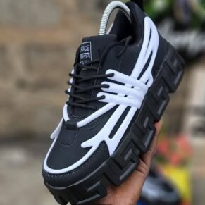 Sneakers in black and white, with a distinctive Versace logo and a thick, platform sole. Designed for Nigerian shoppers seeking trendy footwear.