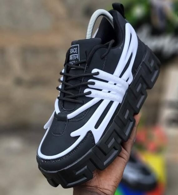 Sneakers in black and white, with a distinctive Versace logo and a thick, platform sole. Designed for Nigerian shoppers seeking trendy footwear.