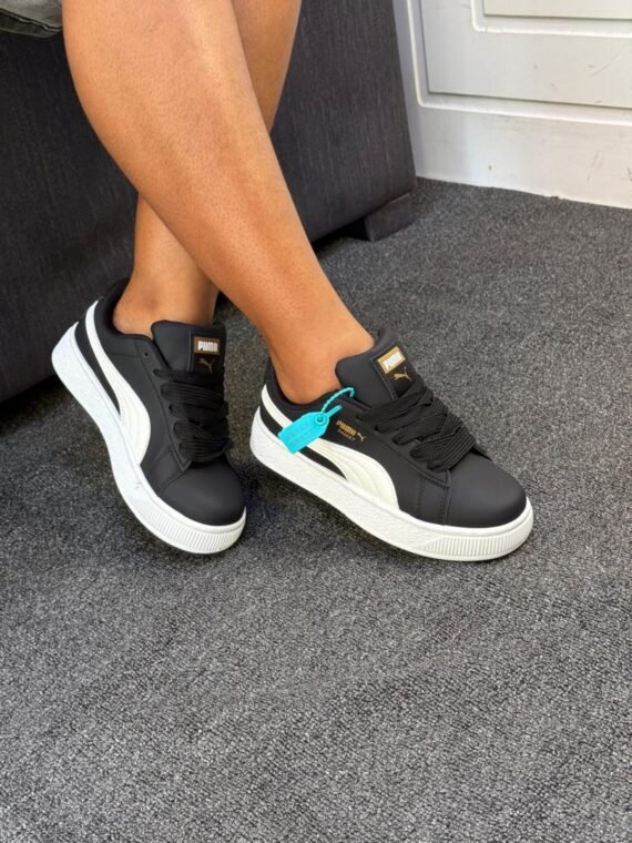 Sneakers on a person's feet, showcasing the Puma Cravat's sleek design and comfortable fit.