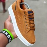 Sneakers with a unique pattern and vibrant orange laces. Designed for all-weather wear and a stylish touch for any outfit.