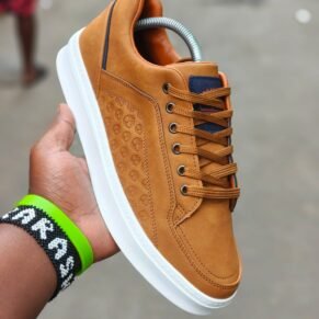 Sneakers with a unique pattern and vibrant orange laces. Designed for all-weather wear and a stylish touch for any outfit.